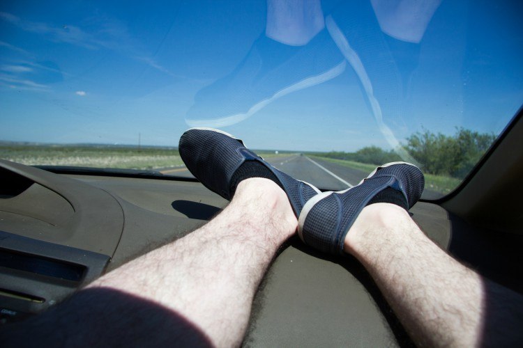Men's feet up on dashboard.