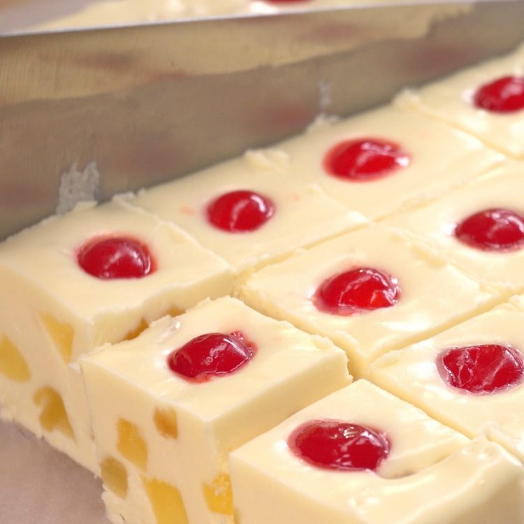 Cutting pineapple upside-down cake fudge into pieces