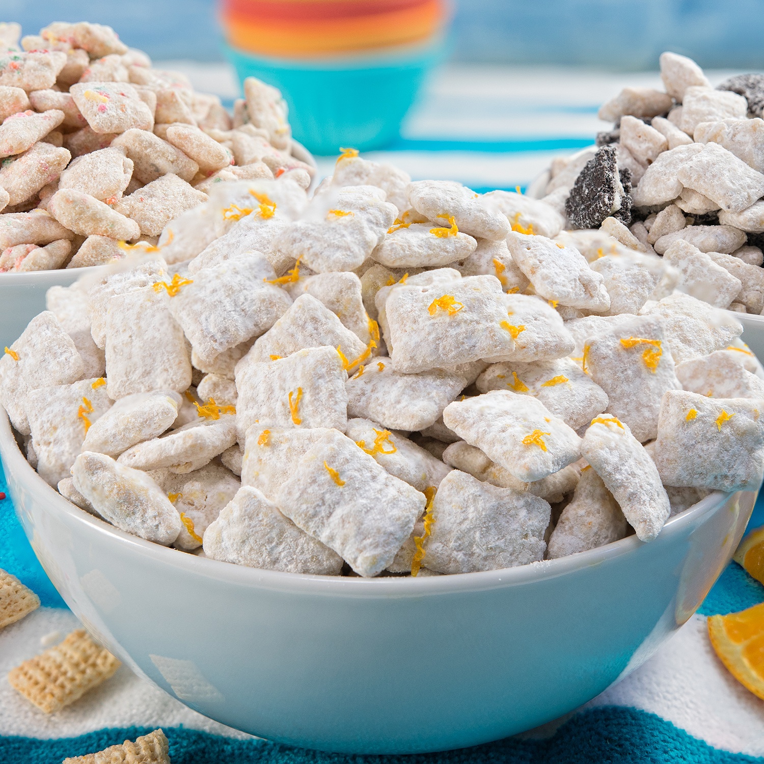 Three easy Muddy Buddies flavors that taste like summer: Cake Batter, Orange Creamsicle, and Cookies & Cream. These no-bake 10-minute treats are pure fun.