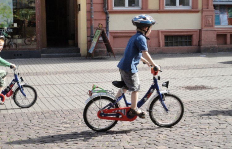 kids riding on bikes on town road
