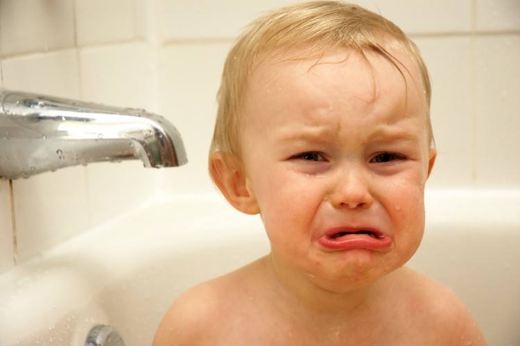 Baby crying in bath tub.